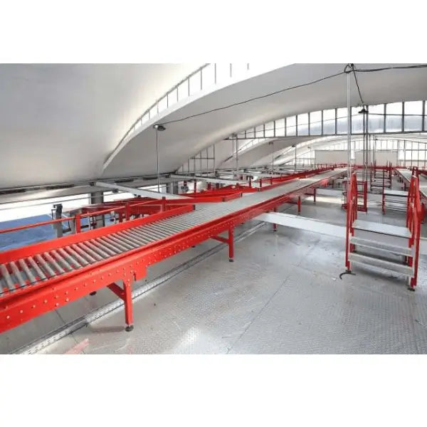 Curved gravity roller conveyor system installed in warehouse environment with steel frame and industrial rollers for material handling
