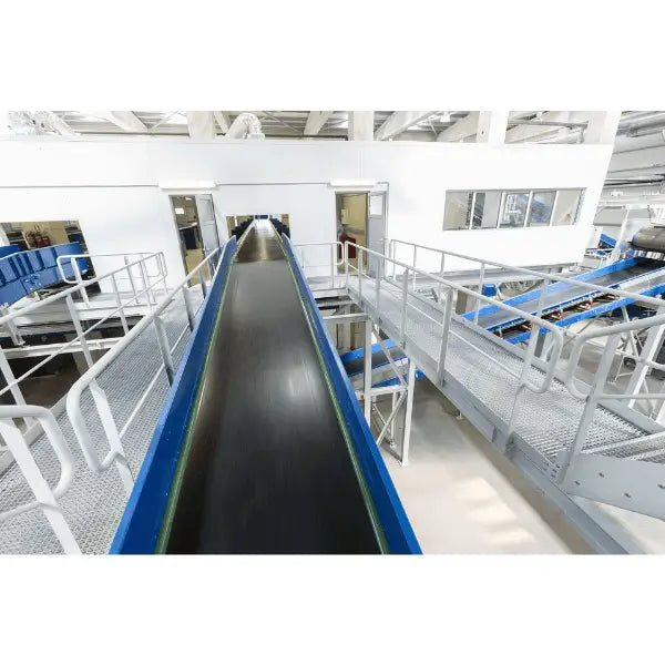 Trough bed belt conveyor in warehouse setting for industrial bulk material handling operations
